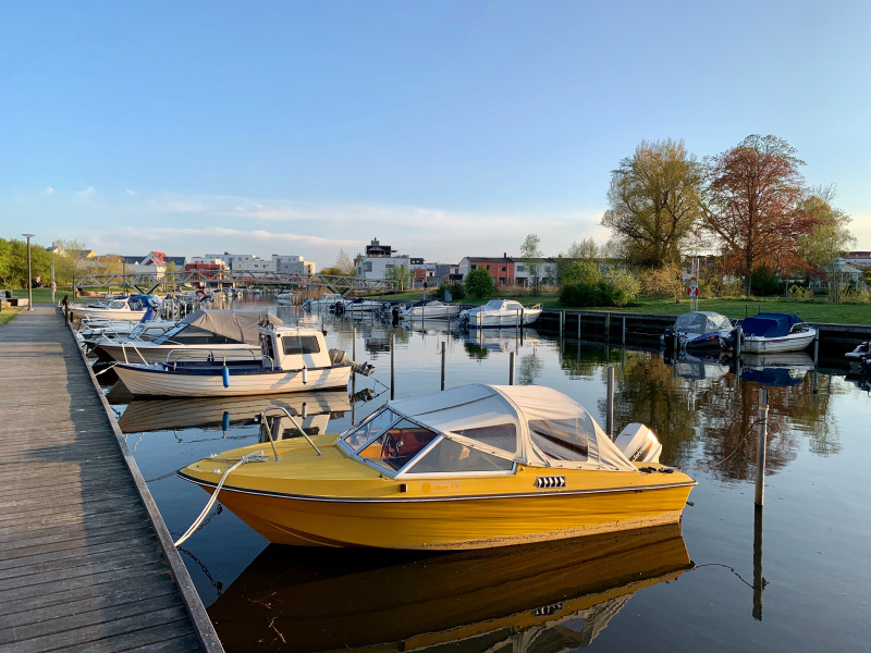 Boat docked in a harbor with calm water and surrounding boats