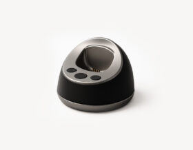 MiniFinder Pico charging base on white background, showing magnetic dock designed for easy cable-free charging.