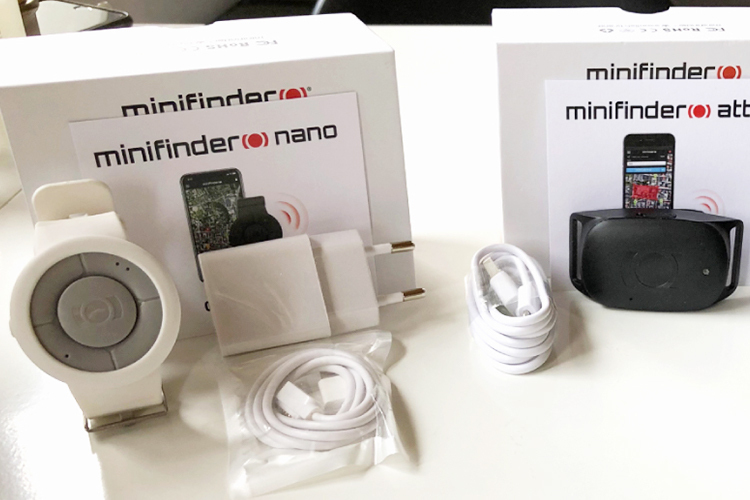 MiniFinder Nano and Atto Pro with product boxes, charger, adapter on a table