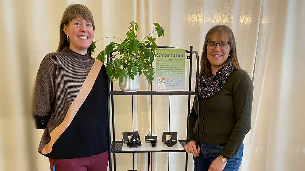 Two women represenatatives from Smartoteket standing beside a shelf with MiniFinder products